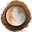 A top-down view of a black-rimmed cup of latte art hojicha surrounded by a circular pile of hojicha powder on a white background.