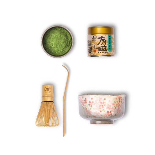 matcha set with a matcha whisk, a chashaku, grey matcha bowl with flowers and ceremonial matcha